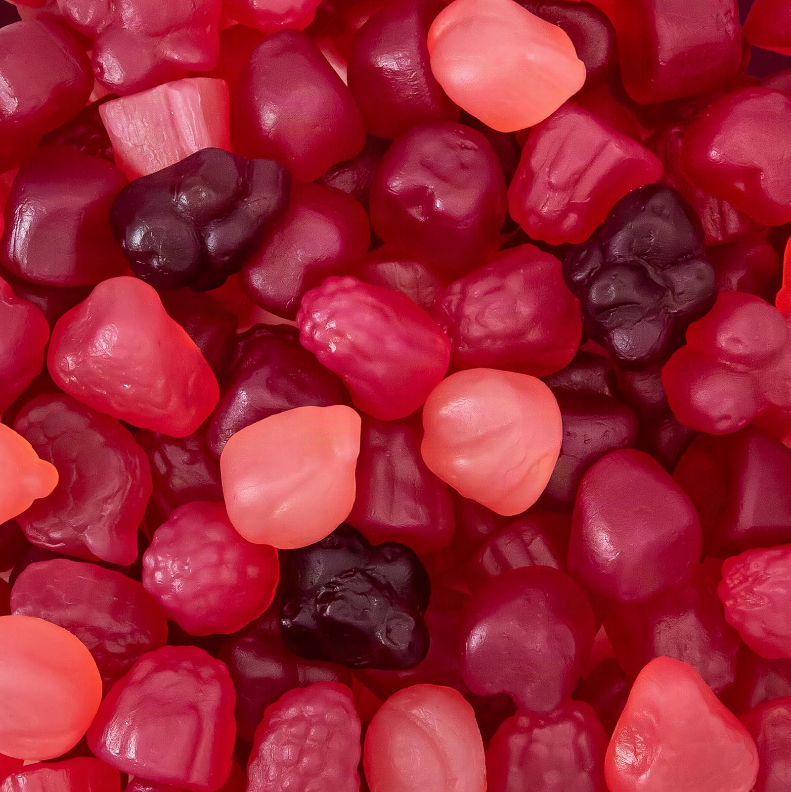 Macro close-up of colorful translucent berry jelly gummies with shallow depth of field